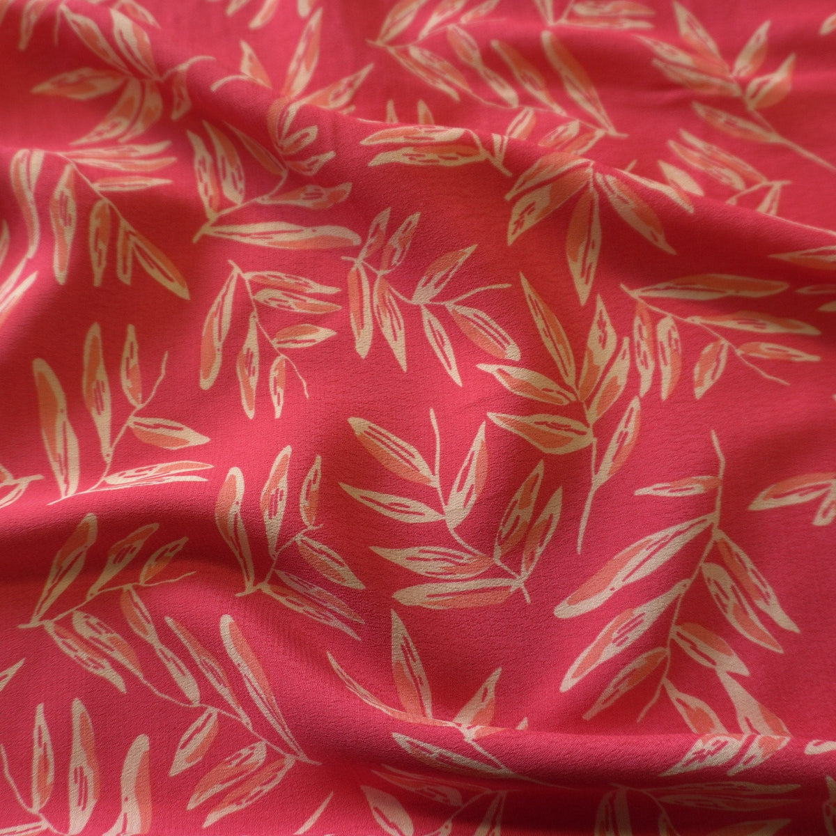 Cream leaves on pink viscose dual crepe fabric